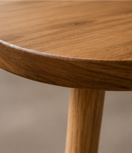 Gros plan sur le plateau et le pied en bois de la table Auberive
