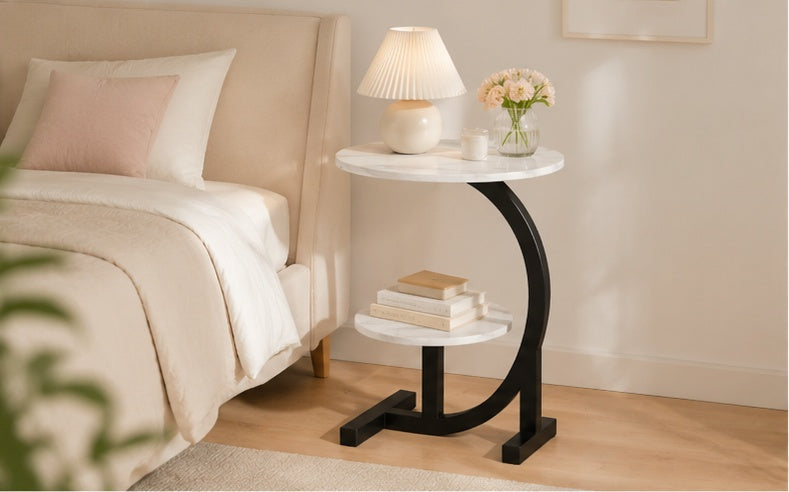 Table d'appoint ronde en marbre blanc avec pied noir arrondi dans une chambre cosy