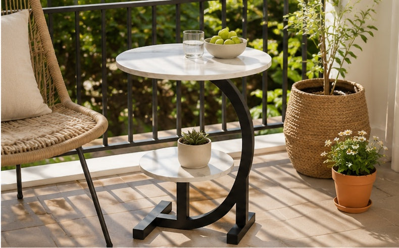 Table d'appoint ronde en marbre blanc sur un balcon avec fauteuil en rotin et plantes