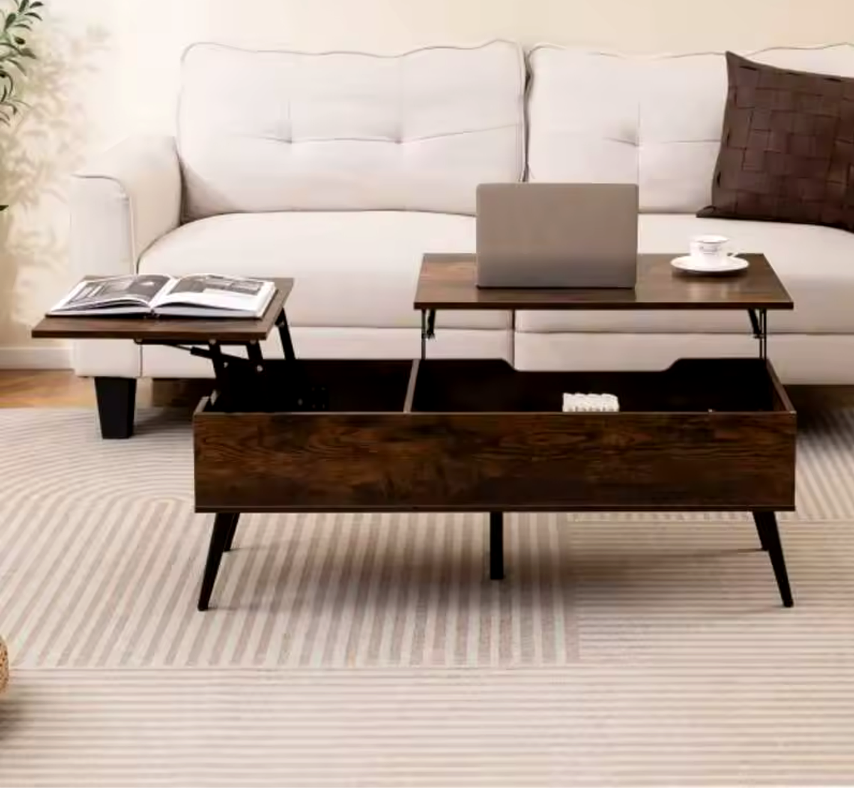 Table basse relevable Kadria avec plateaux ouverts, ordinateur et livre dans un salon crème