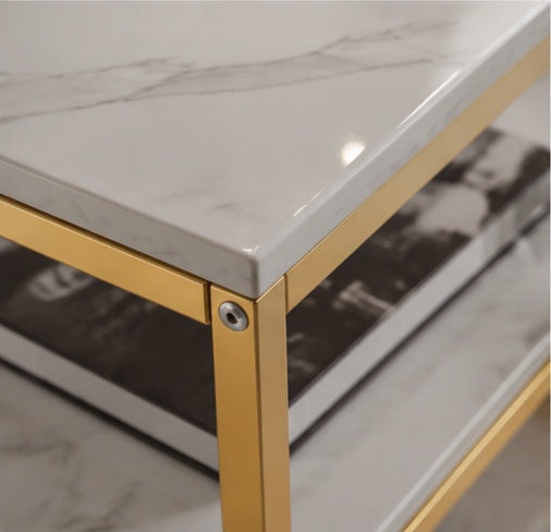 Gros plan sur le plateau en marbre blanc et la structure dorée de la table Marbella